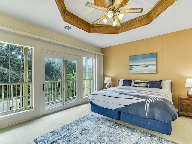 carpeted bedroom with access to exterior, crown molding, a raised ceiling, and a textured ceiling