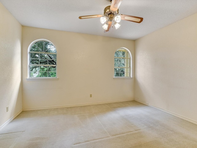 carpeted empty room with ceiling fan and a textured ceiling