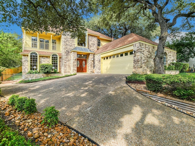 mediterranean / spanish-style home with a garage, french doors, and a balcony