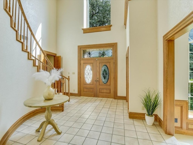 foyer with a high ceiling and light tile patterned floors