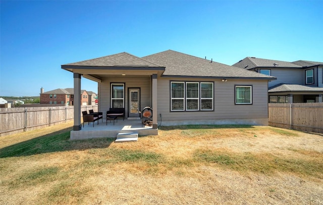 back of property with a lawn, a patio area, and a fenced backyard