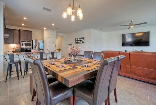 dining space featuring ornamental molding, light tile patterned flooring, and ceiling fan with notable chandelier