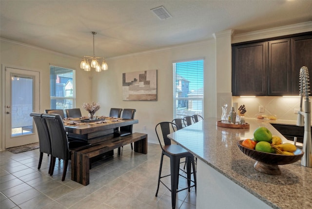 dining space featuring ornamental molding, light tile patterned floors, and a wealth of natural light