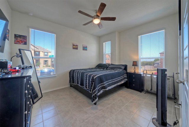 tiled bedroom with multiple windows and ceiling fan