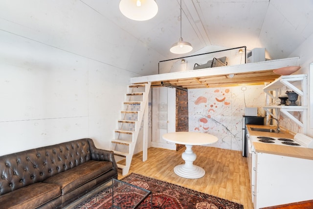 bathroom with hardwood / wood-style flooring, vaulted ceiling, and sink