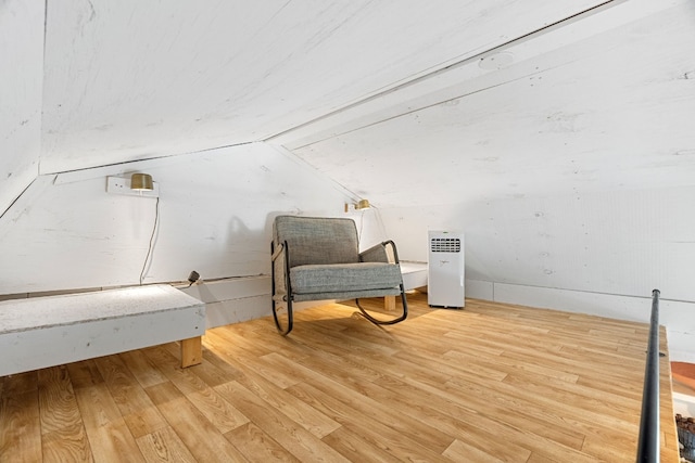 sitting room with hardwood / wood-style floors and vaulted ceiling