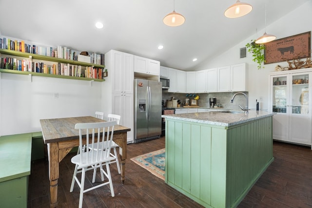 kitchen with sink, dark hardwood / wood-style floors, vaulted ceiling, decorative light fixtures, and appliances with stainless steel finishes