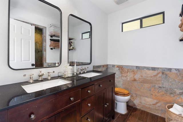 bathroom featuring toilet, vanity, tile walls, and hardwood / wood-style flooring