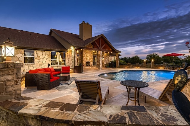 pool at dusk featuring a patio area, pool water feature, and outdoor lounge area