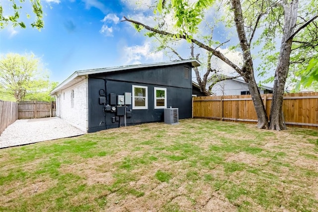 rear view of house with a yard, a patio, and central AC