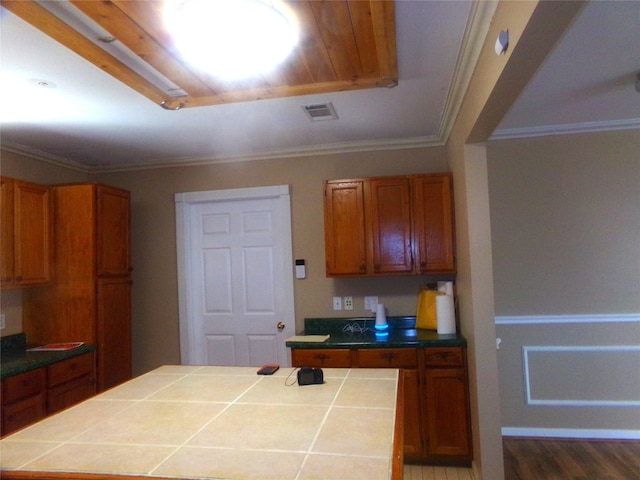 kitchen with tile counters, ornamental molding, and dark hardwood / wood-style floors