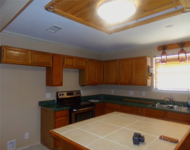 kitchen with electric stove, crown molding, sink, and tile counters