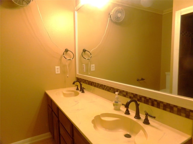 bathroom featuring vanity, crown molding, and toilet