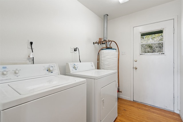 clothes washing area with light hardwood / wood-style floors and washing machine and dryer