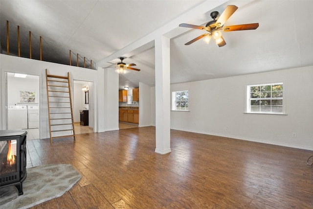 unfurnished living room with ceiling fan, hardwood / wood-style flooring, high vaulted ceiling, and washing machine and clothes dryer