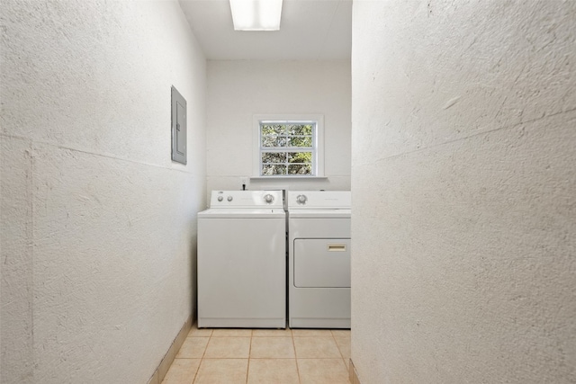 clothes washing area featuring electric panel, separate washer and dryer, and light tile patterned floors