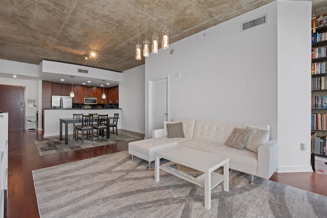 living room with baseboards, visible vents, and dark wood-style flooring