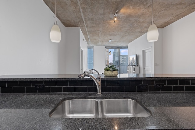 kitchen with dark countertops, a sink, and decorative light fixtures