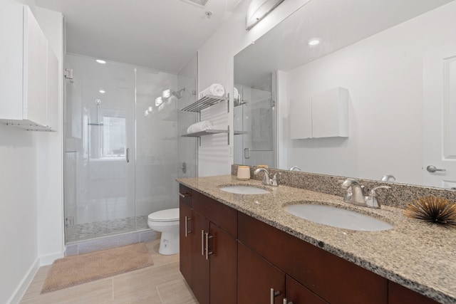 bathroom featuring vanity, a shower with shower door, tile patterned floors, and toilet