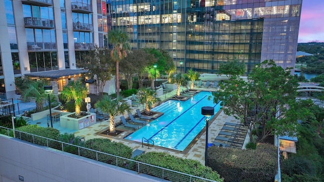 pool at dusk with a patio area