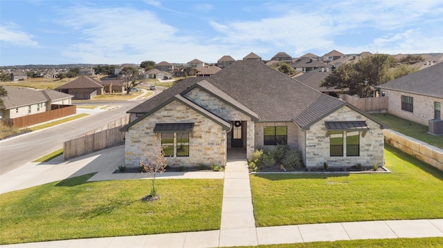 view of front of property with central AC and a front yard