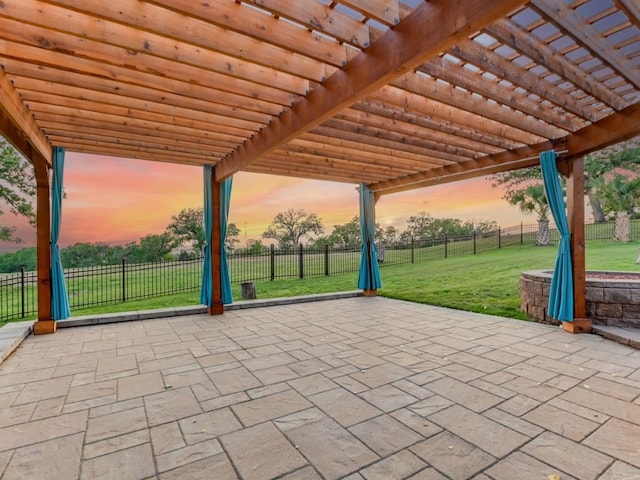 patio terrace at dusk featuring a lawn and a pergola