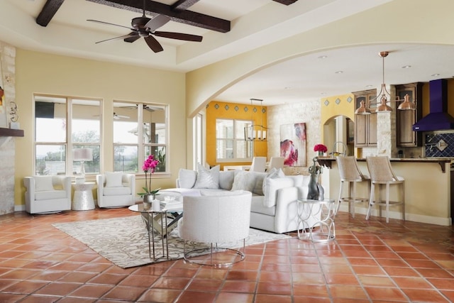 living room featuring ceiling fan, beamed ceiling, and tile patterned flooring