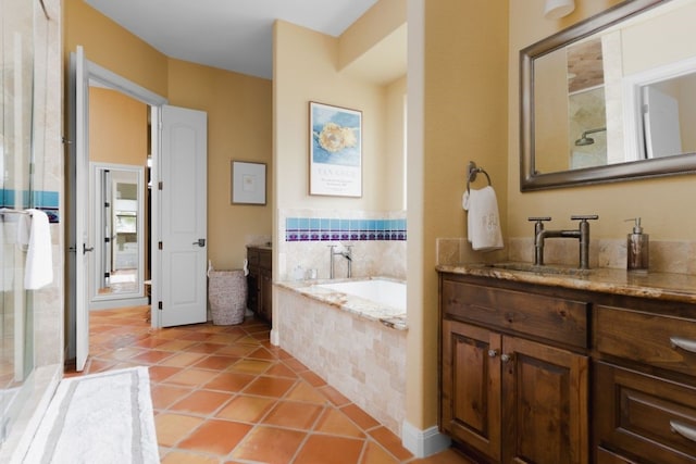 bathroom featuring vanity, tiled bath, and tile patterned flooring