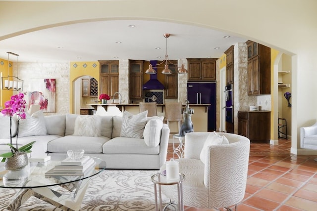 living room featuring sink, an inviting chandelier, and tile patterned flooring