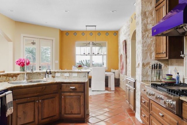 kitchen with light tile patterned floors, white dishwasher, hanging light fixtures, stainless steel gas stovetop, and exhaust hood