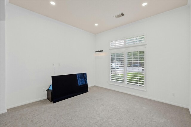 spare room with light carpet and crown molding