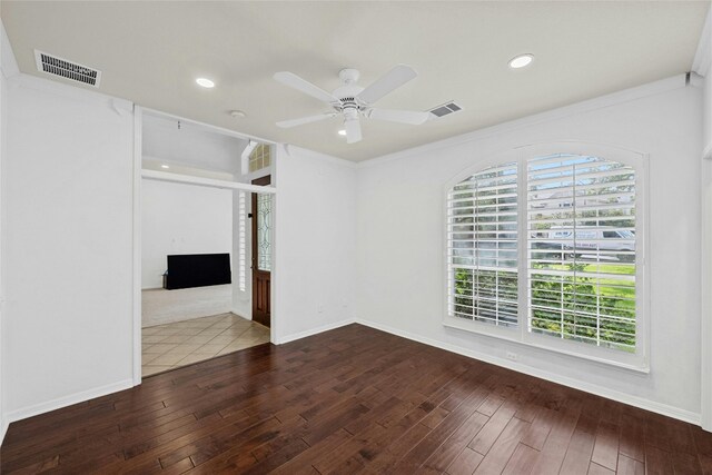 empty room with crown molding, wood-type flooring, and ceiling fan