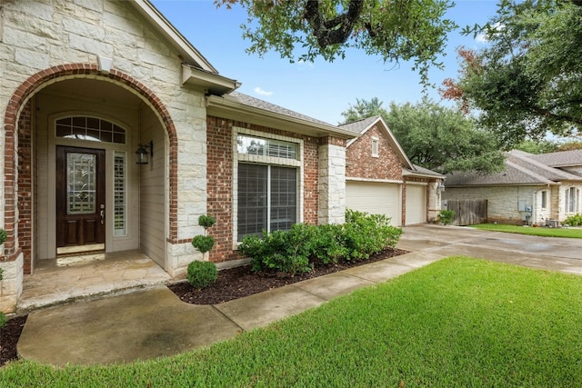 view of exterior entry with a yard and a garage