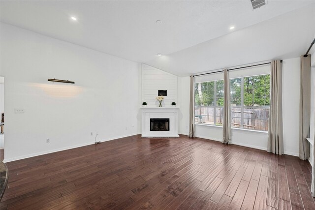 unfurnished living room with dark wood-type flooring, a fireplace, and vaulted ceiling