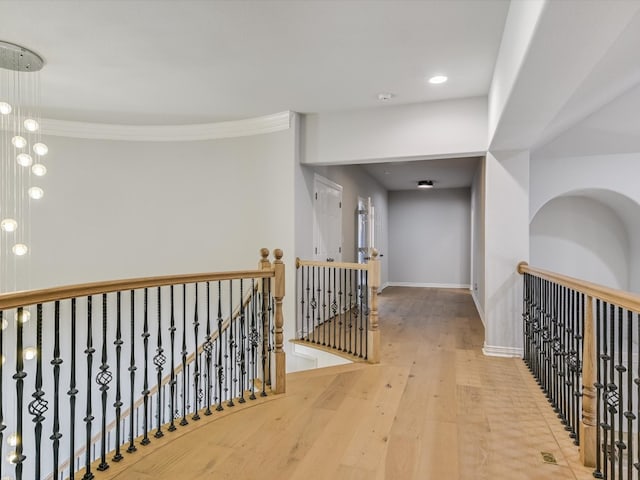 corridor featuring ornamental molding and hardwood / wood-style floors