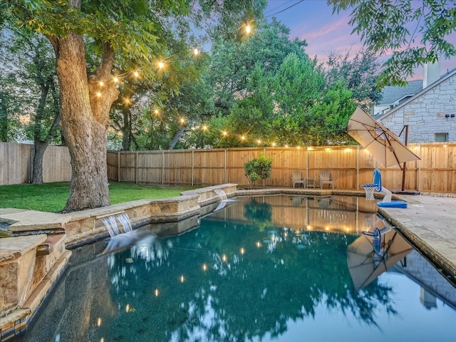 pool at dusk featuring a lawn