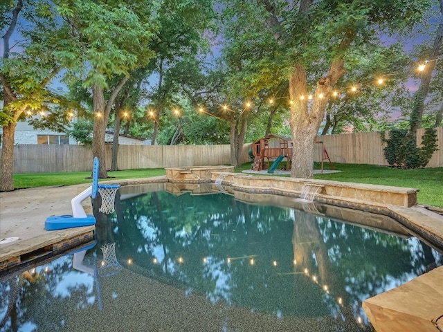 view of pool with pool water feature, a lawn, and a playground