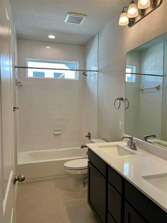 full bathroom with vanity, a textured ceiling, tile patterned floors, and tiled shower / bath