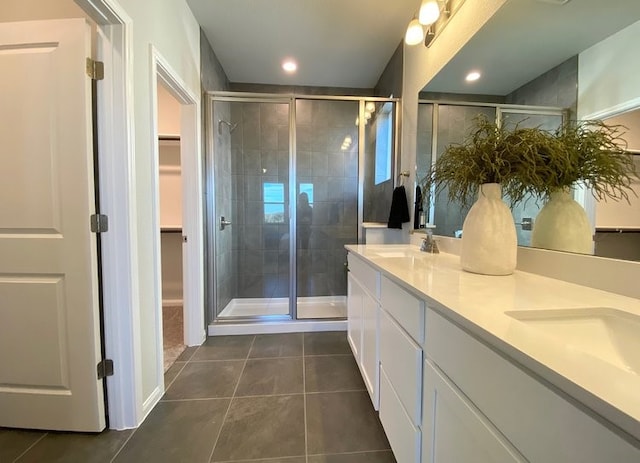 bathroom featuring tile patterned flooring, vanity, and a shower with door