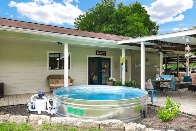 view of pool with french doors, a deck, and ceiling fan