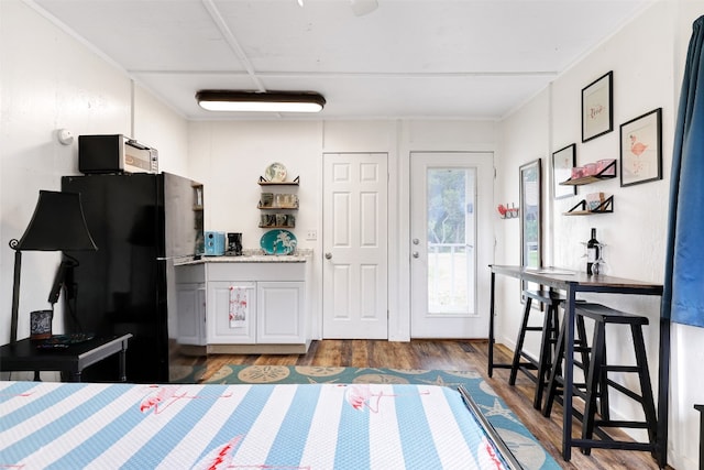 kitchen with black refrigerator and wood-type flooring