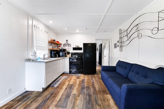 kitchen featuring sink, black appliances, white cabinetry, and dark hardwood / wood-style flooring