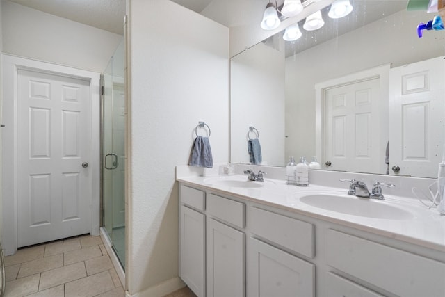 bathroom featuring vanity, tile patterned floors, a textured ceiling, and an enclosed shower