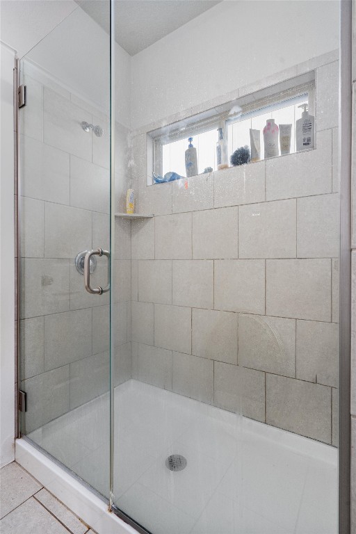 bathroom with tile patterned floors and walk in shower