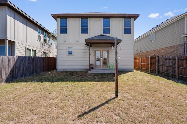 back of house with french doors and a yard