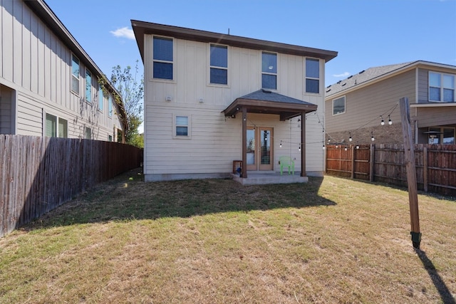 back of house with a yard and a patio