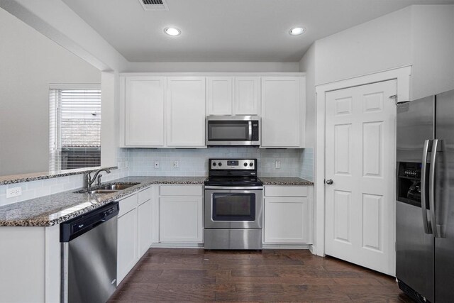 16304 Travesia Way, Austin, TX 78728 - kitchen featuring appliances with stainless steel finishes, stone counters, white cabinetry, backsplash, and dark wood finished floors