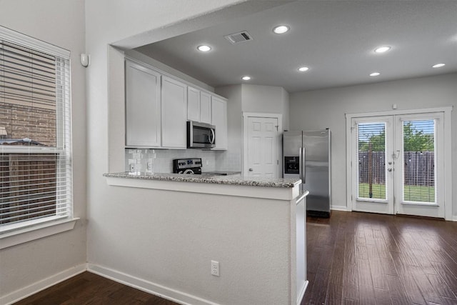 16304 Travesia Way, Austin, TX 78728 - kitchen with stainless steel appliances, dark wood-style floors, light stone counters, backsplash, and recessed lighting