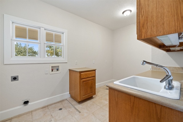 clothes washing area featuring cabinets, sink, washer hookup, a textured ceiling, and hookup for an electric dryer