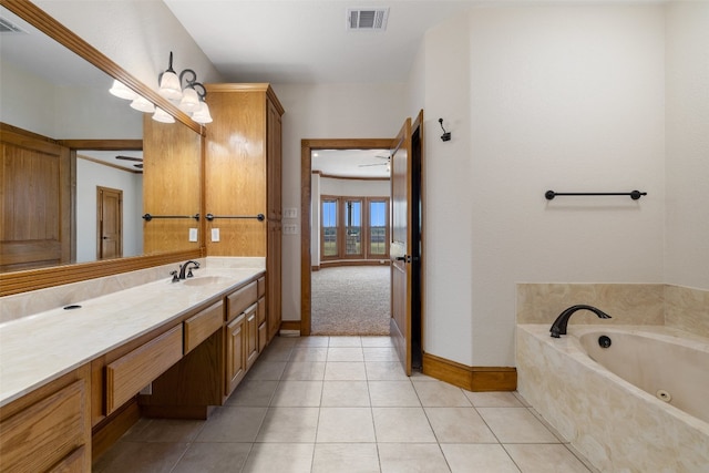 bathroom featuring tiled tub, tile patterned flooring, and vanity